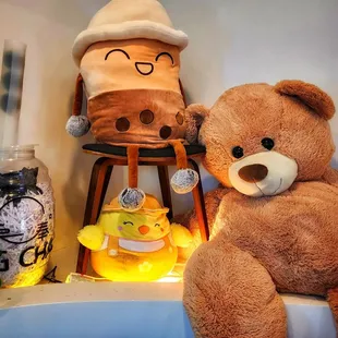 a brown teddy bear sitting on a stool