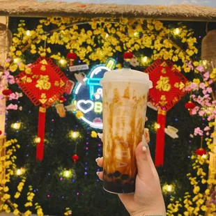 a hand holding a cup of iced coffee