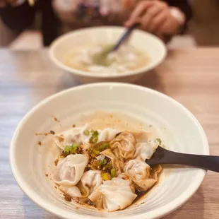 a woman eating dumplings in a bowl