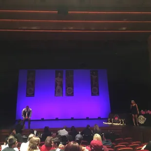 a stage with people sitting in chairs