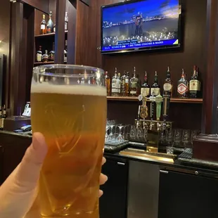 a hand holding a pint of beer