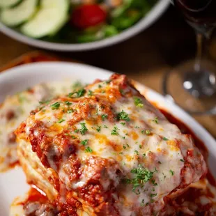 a plate of lasagna and a glass of red wine