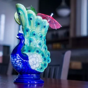 a blue vase with a peacock on it