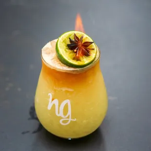 a cocktail with a lime garnish
