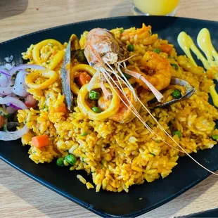 a plate of rice with shrimp and vegetables