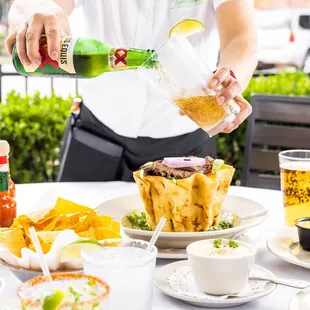 a woman pouring a bottle of beer