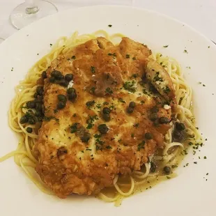 a plate of pasta with chicken and olives