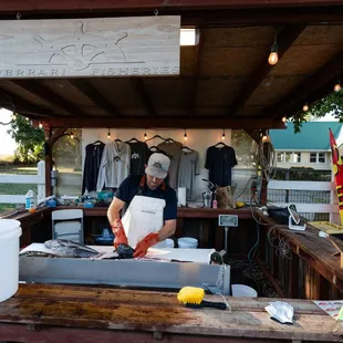 a man cutting fish on a grill