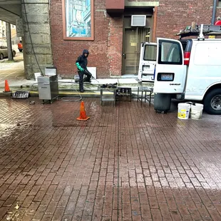 a man cleaning a sidewalk