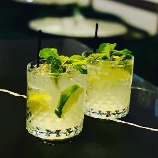 two cocktails with lime and mint