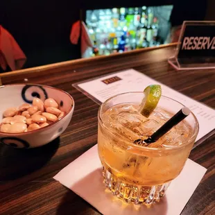 a glass of wine and a bowl of nuts