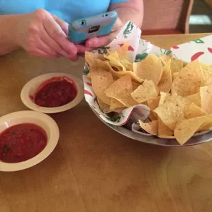 a plate of nachos and bowls of salsa