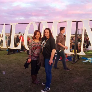 two women standing in front of a sign that says palomino