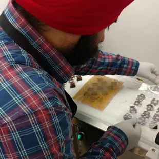 Putting cocoa butter patterns on top of chocolate truffles.