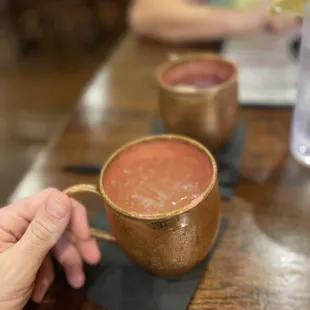 a hand holding a cup of soup