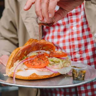 a person holding a plate with a sandwich on it