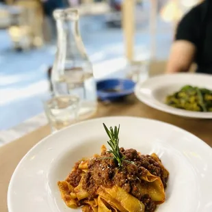 a plate of pasta with a sprig of rosemary