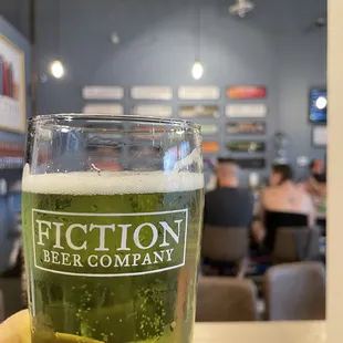  a hand holding a pint of beer