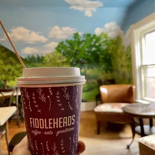 a hand holding a cup of coffee