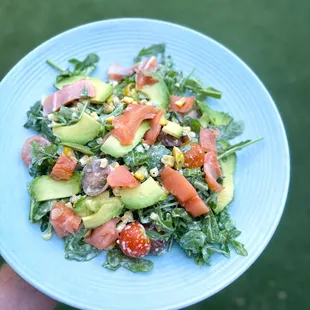 a person holding a plate of salad