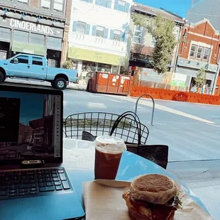a laptop and a sandwich on a table