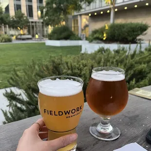 a hand holding a glass of beer