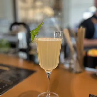 a glass of white wine with a garnish