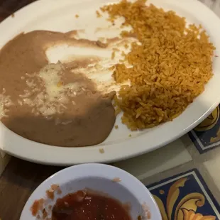 A plate of partially eaten beans &amp; rice. Note the beans are soupy, paste-like rather than refried beans.