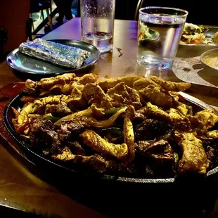 Steak &amp; Chicken Fajitas. Fundido, rice, and condiments in background