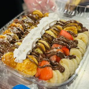 Delicious fluffy warm mini pancakes topped with Nutella, fresh strawberries and bananas