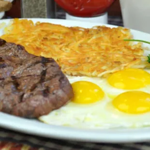 a steak, eggs, hash browns, and hash browns