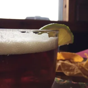 a glass of beer with a lime wedge