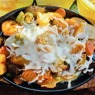 Bistec el Patron (Ribeye topped with shrimp, roasted potatoes, mixed vegetables, and cheese)