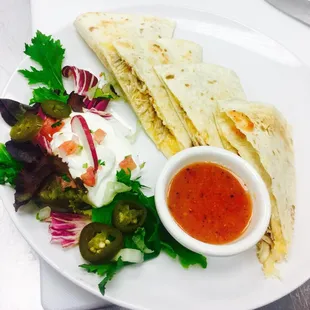 quesadilla and salad on a white plate