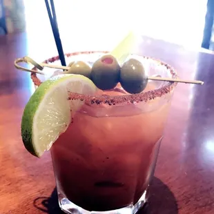 a margarita with olives and a lime garnish