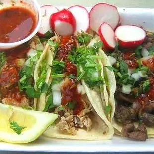 a plate of tacos with salsa and radishes