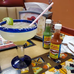 a margarita in a glass with a straw and lime
