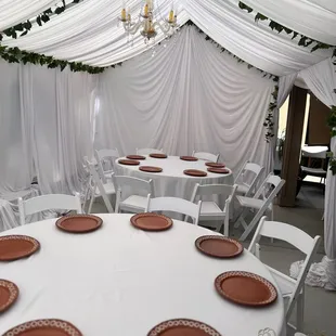 All white draping with greenery and crystal chandeliers