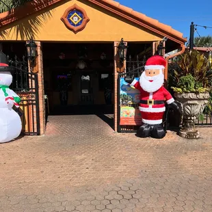 santa and snowman in front of a store