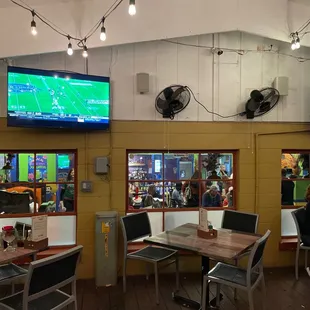 people sitting at tables watching televisions