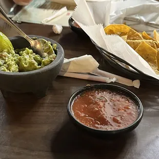 salsa, guacamole and chips on a table