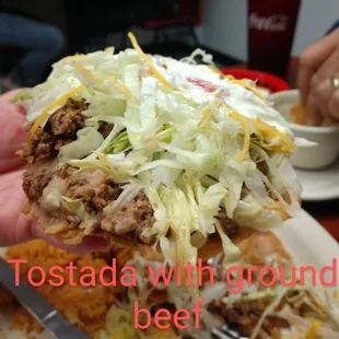 a hand holding a taco with ground beef