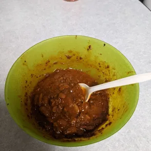 a bowl of chili sauce with a spoon in it
