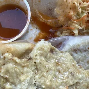 a plate of food with sauce and coleslaw