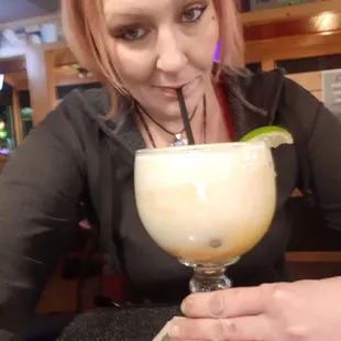 a woman drinking a margarita