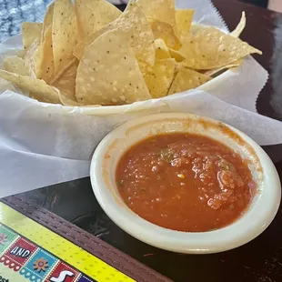 a bowl of chips and a bowl of salsa