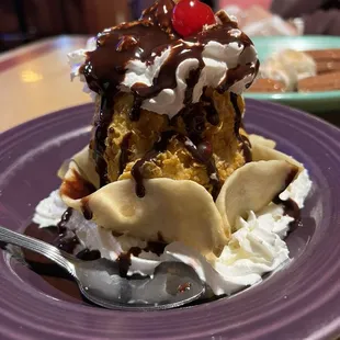 a banana split on a purple plate