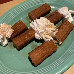 a plate of cinnamon rolls with whipped cream