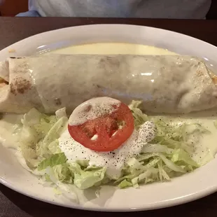 a burrito and salad on a white plate