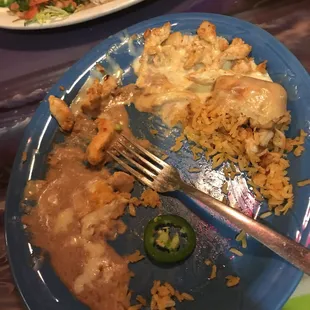 a blue plate with rice, chicken, and jalapeno peppers